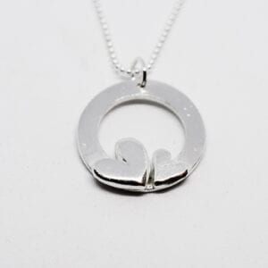 silverhänge med två hjärtan i kedja mot vit bakgrund