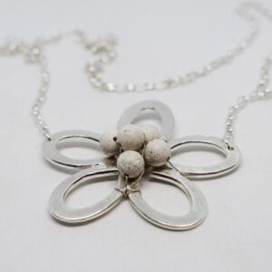 silverblomma med stenar i mitten på vit bakgrund