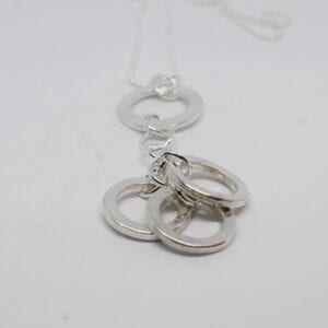 silverhalsband med ringar på vit botten