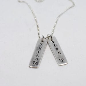 silversmycke namnbrickor mot vit bakgrund