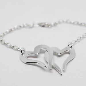 två hjärtan i kedja som armband på vit bakgrund