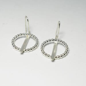 silverörhängen på vit botten