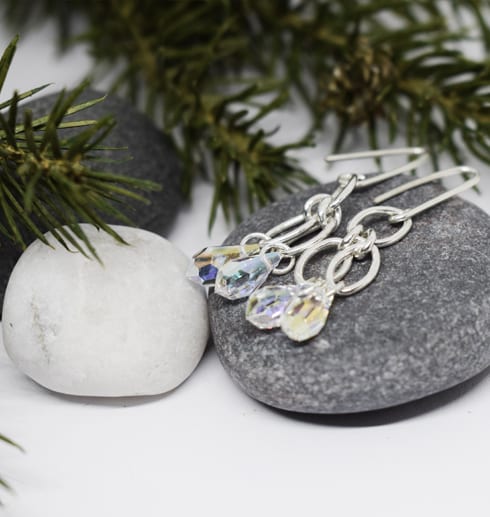 silverörhängen mot stenar och grankvistbakom