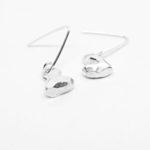 silverörhängen i form av hjärtan på vit botten