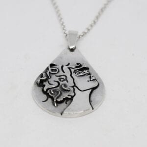 droppformat silversmycke med kvinnoansikte på vit bakgrund