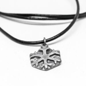 silverstjärna i läderrem på vit botten