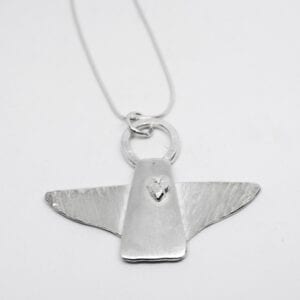 silverängel i kedja mot vit bakgrund
