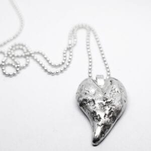 silverhjärta i kedja med vit bakgrund