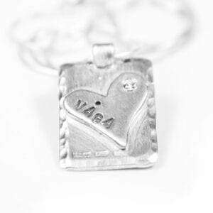 silversmycke med hjärta och text på vit bakgrund