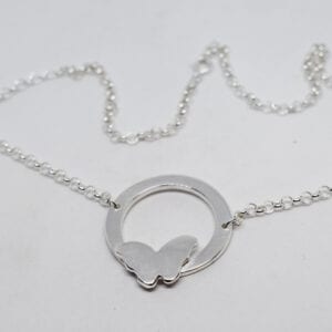 silverhalsband med fjäril på vit botten