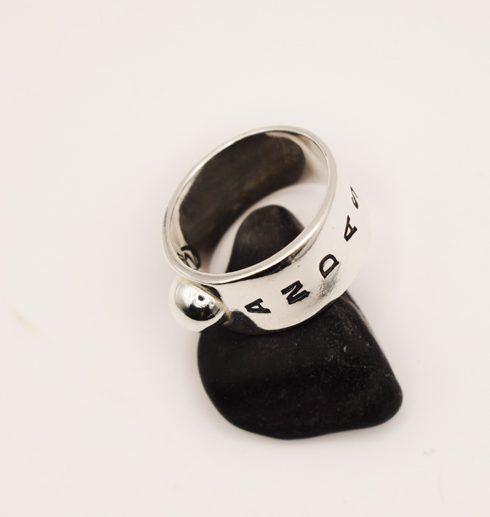 silverring på svart sten med text